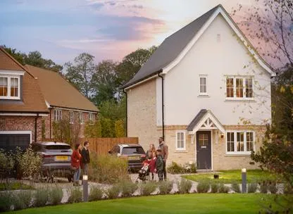 Couple and young family chatting outside new homes on the Millside Grange development