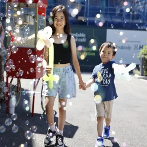 Communities at North Gate Park, two young children playing with bubbles